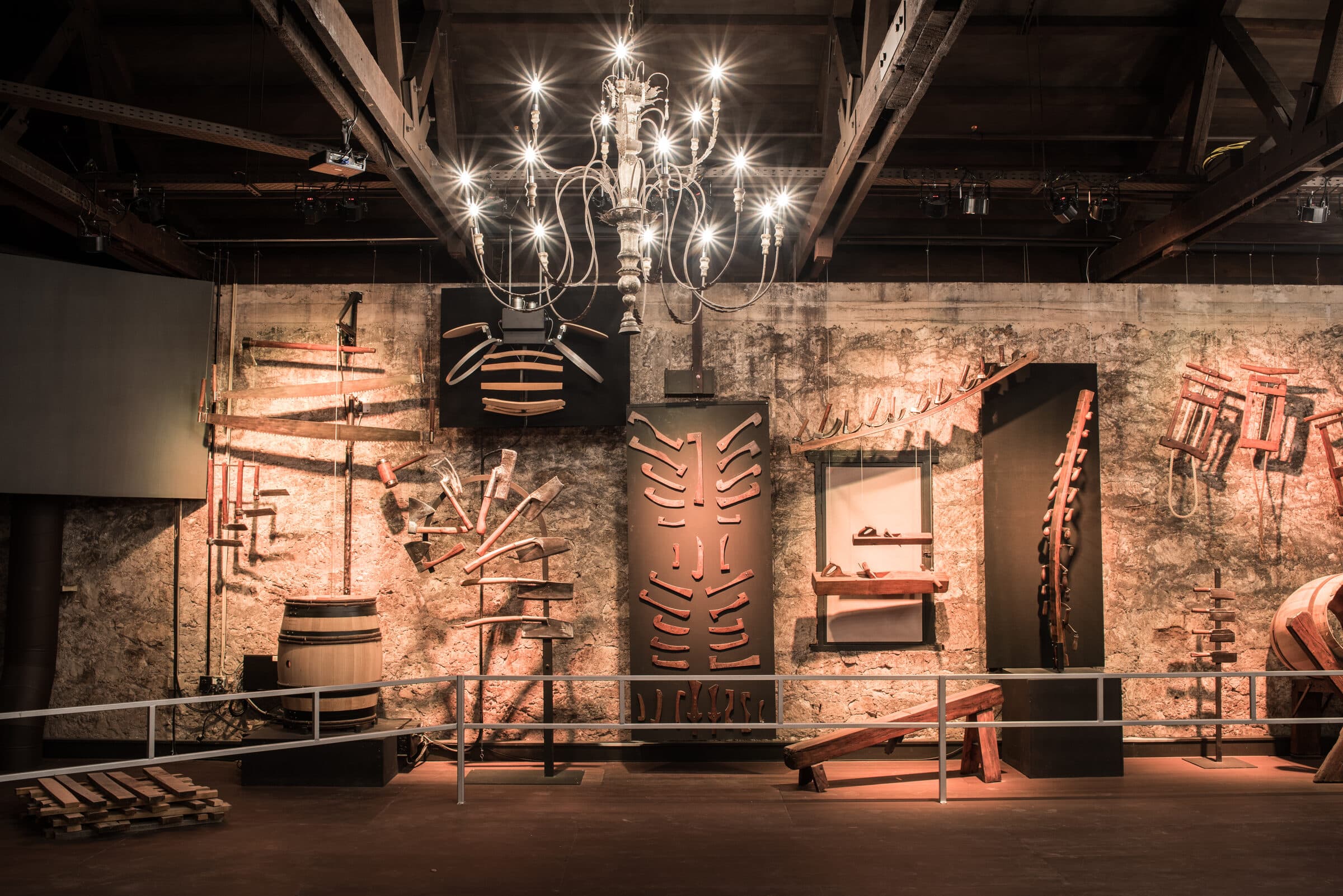 Antique vineyard tools mounted on the stone wall of the Buena Vista tool museum beneath a chandelier